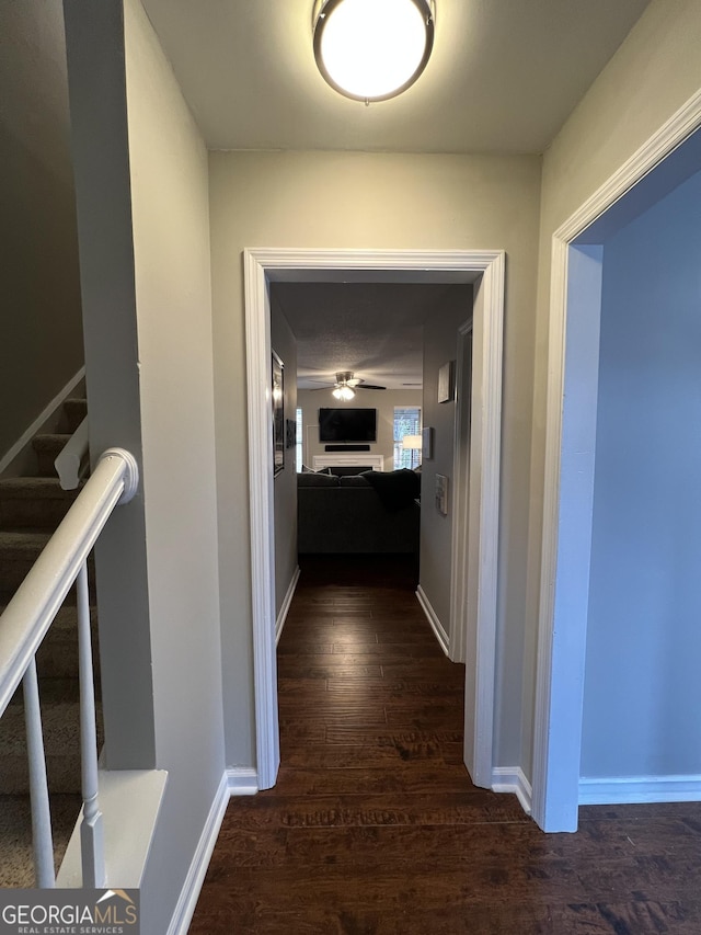 hall featuring stairway, baseboards, and dark wood-style flooring