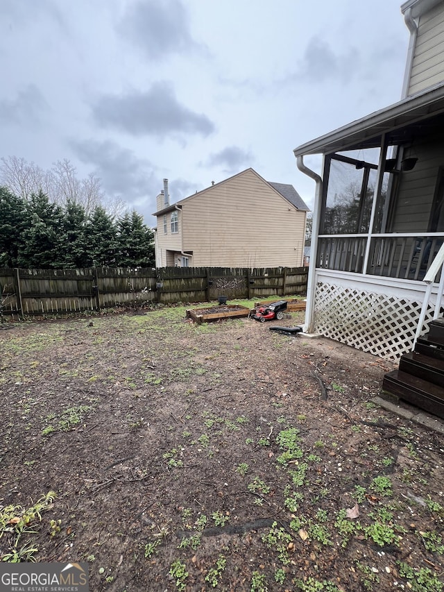 view of yard featuring fence private yard and a sunroom