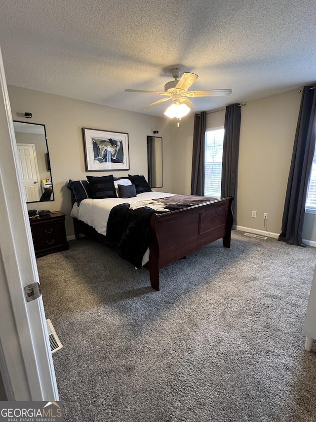 carpeted bedroom featuring visible vents, baseboards, a textured ceiling, and a ceiling fan