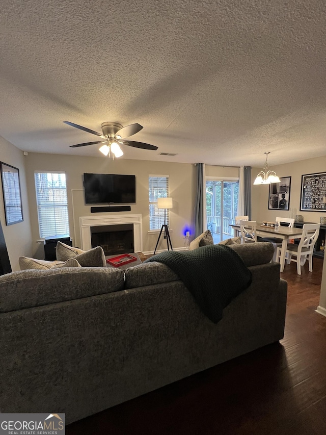 living area with visible vents, a healthy amount of sunlight, dark wood finished floors, and a fireplace