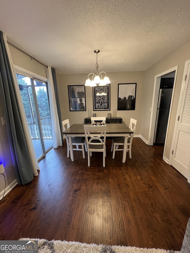 dining space with dark wood finished floors, baseboards, a textured ceiling, and an inviting chandelier