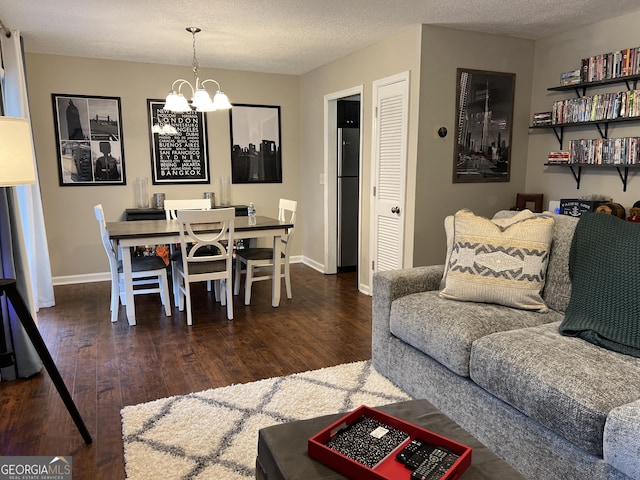 living room featuring a textured ceiling, an inviting chandelier, and wood finished floors