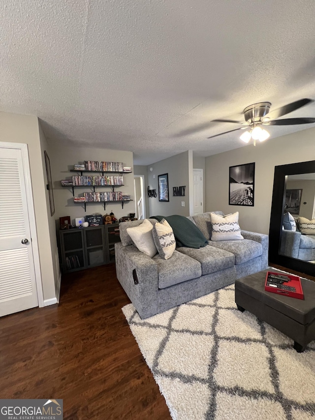 living room with a textured ceiling, a ceiling fan, and wood finished floors