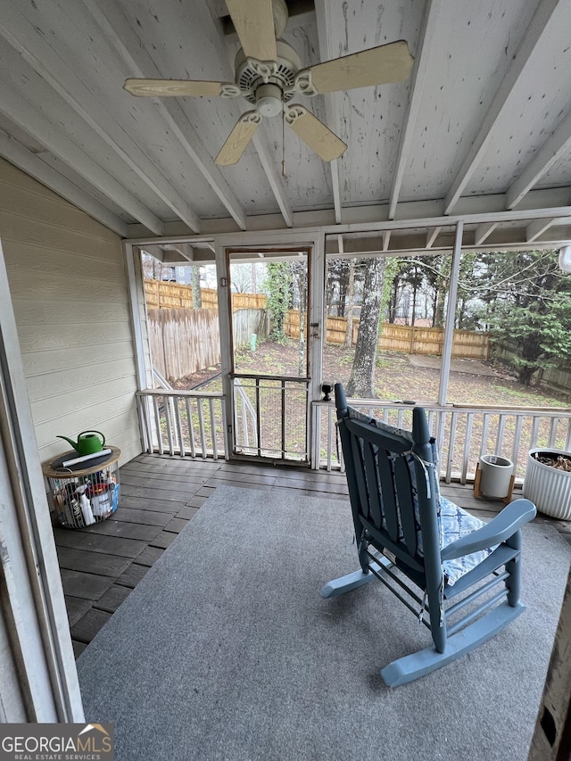 sunroom with lofted ceiling, plenty of natural light, and a ceiling fan