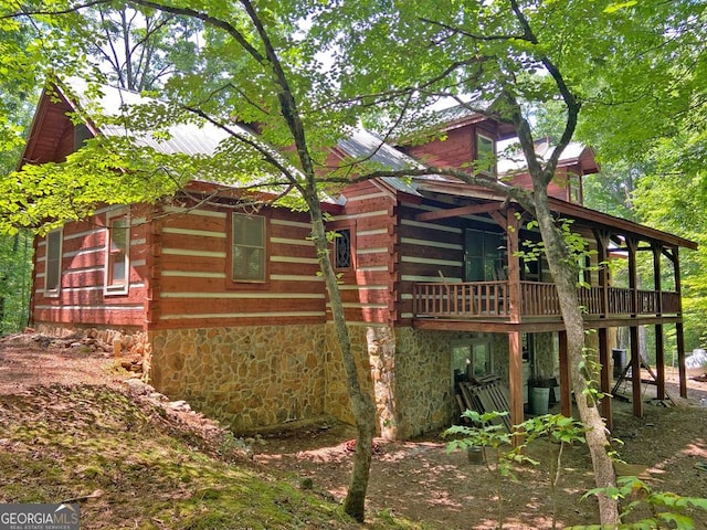 view of property exterior with log siding and a wooden deck