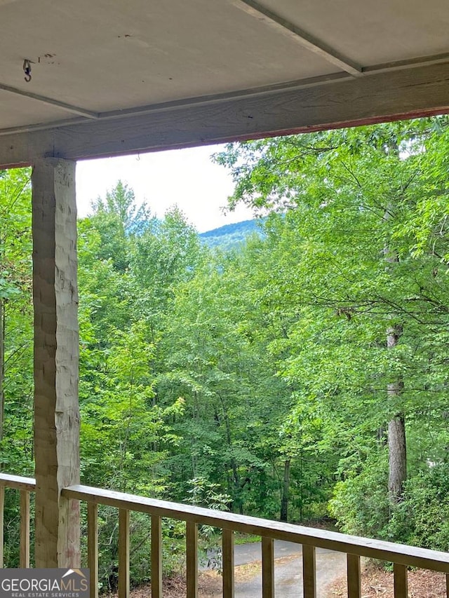 balcony featuring a wooded view