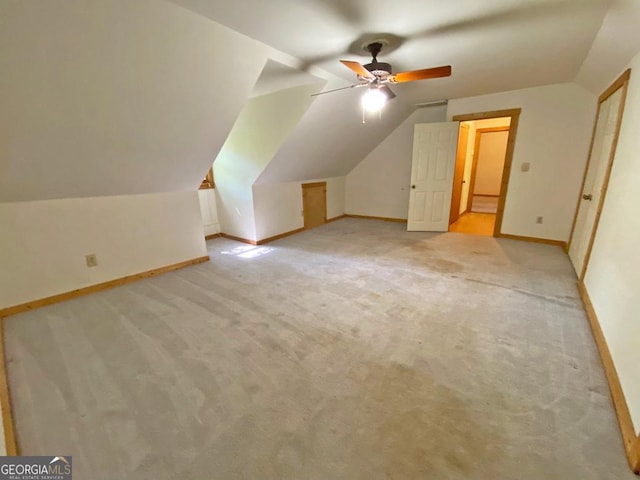 bonus room featuring light colored carpet, baseboards, a ceiling fan, and vaulted ceiling