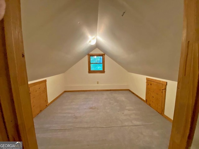 additional living space with lofted ceiling, light colored carpet, and baseboards