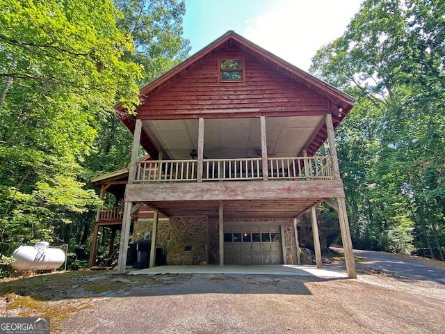 view of front facade with aphalt driveway, stone siding, and an attached garage