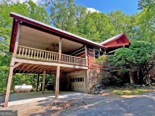 view of front of house with a carport, metal roof, an attached garage, and driveway