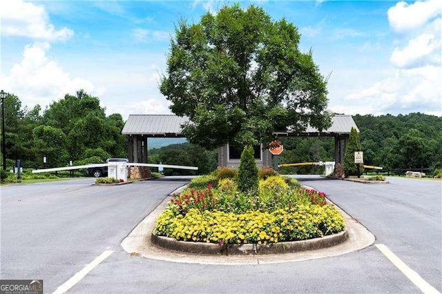 view of street featuring a gated entry and curbs