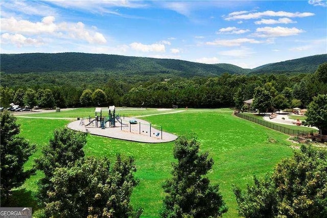 surrounding community with a yard, a wooded view, and a mountain view