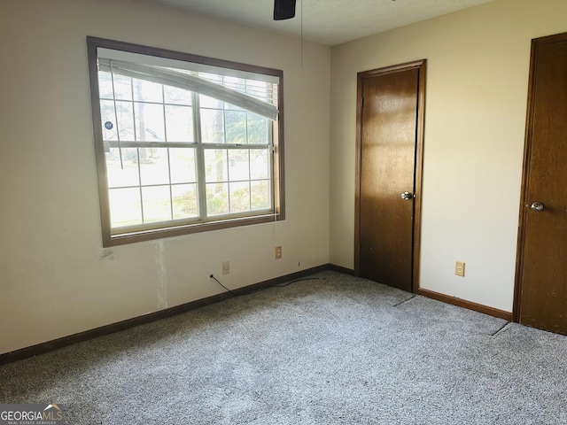 spare room featuring carpet flooring, ceiling fan, and baseboards