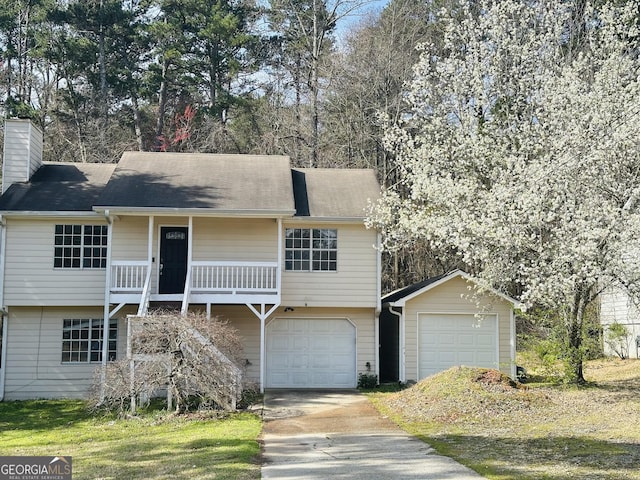 view of front facade featuring concrete driveway, a chimney, and an attached garage