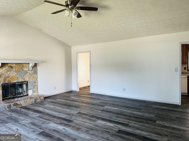 unfurnished living room featuring ceiling fan, vaulted ceiling, a fireplace, dark wood-style floors, and a textured ceiling