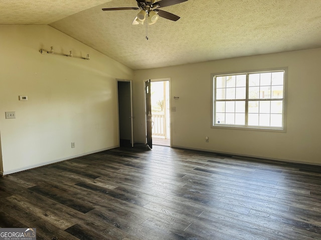 empty room with a textured ceiling, vaulted ceiling, dark wood-style flooring, and ceiling fan