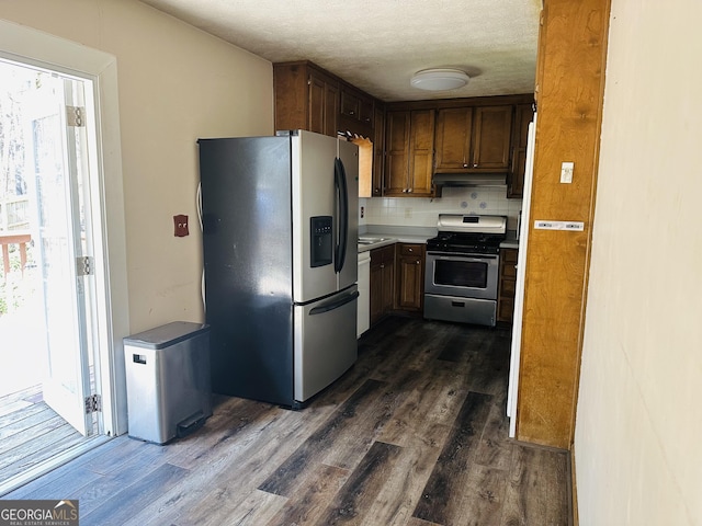 kitchen featuring backsplash, appliances with stainless steel finishes, dark wood finished floors, and light countertops