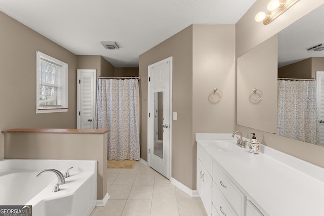 bathroom featuring tile patterned floors, visible vents, a garden tub, baseboards, and vanity