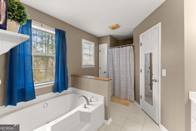 bathroom with curtained shower, a textured ceiling, tile patterned flooring, baseboards, and a bath