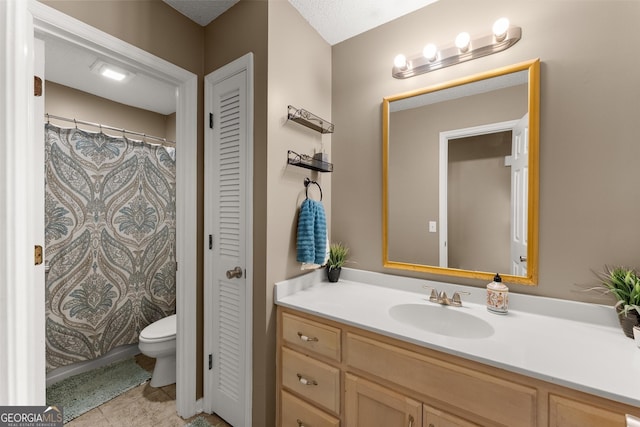 bathroom featuring vanity, tile patterned floors, toilet, and a closet