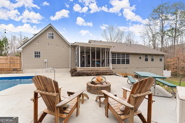 back of house with a fenced in pool, fence, an outdoor fire pit, a sunroom, and a patio area