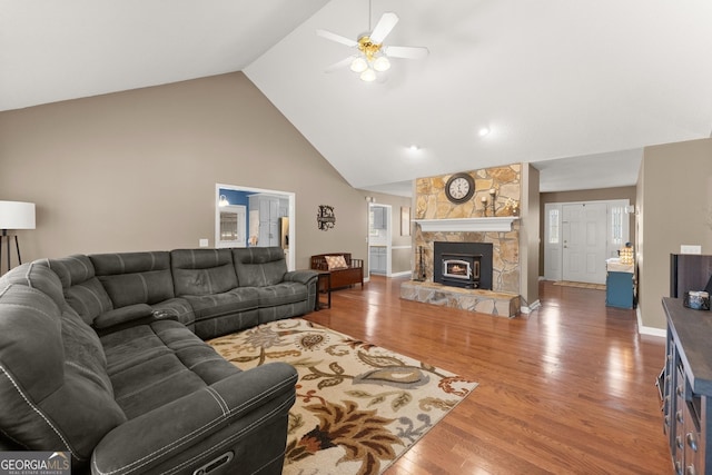 living area featuring wood finished floors, a ceiling fan, baseboards, high vaulted ceiling, and a fireplace