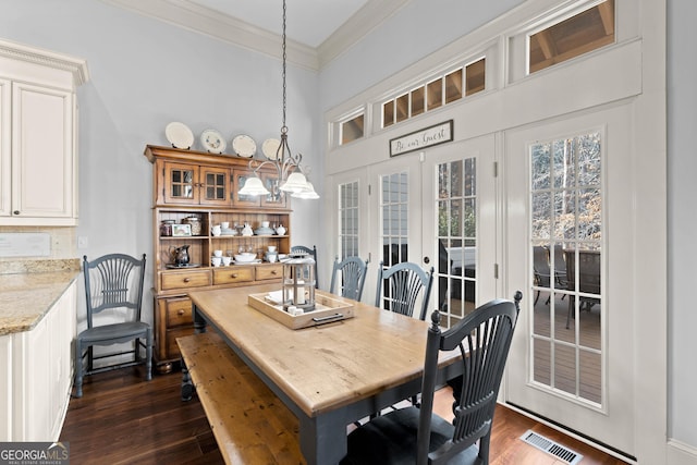 dining room with dark wood finished floors, visible vents, french doors, and ornamental molding