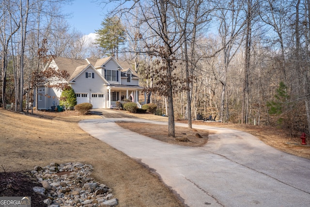 view of front facade featuring a porch, driveway, and an attached garage