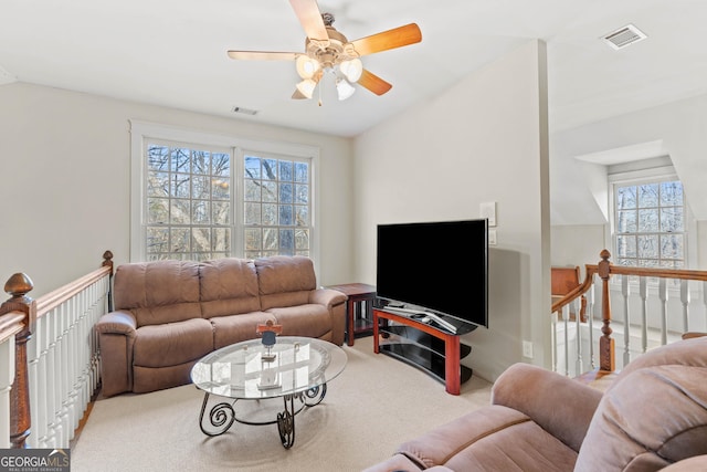 living room with visible vents, lofted ceiling, light colored carpet, and ceiling fan