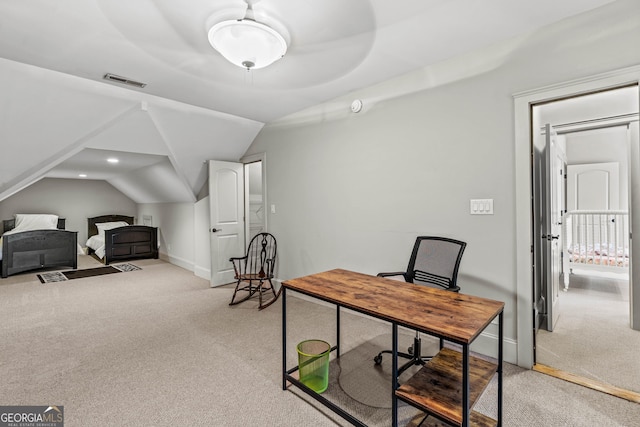 home office with visible vents, light colored carpet, baseboards, and lofted ceiling