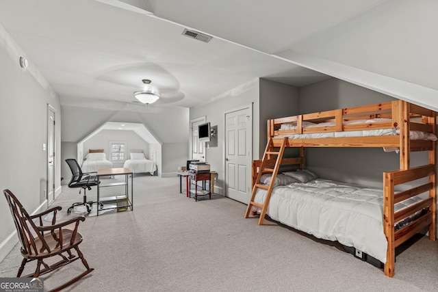 carpeted bedroom featuring visible vents, lofted ceiling, and baseboards