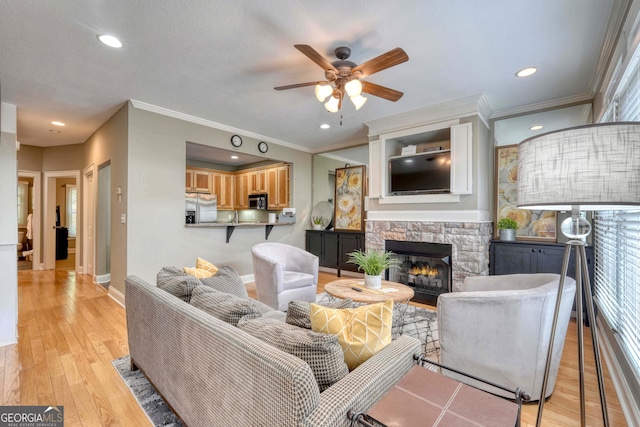 living room with baseboards, recessed lighting, a fireplace, ceiling fan, and light wood-type flooring