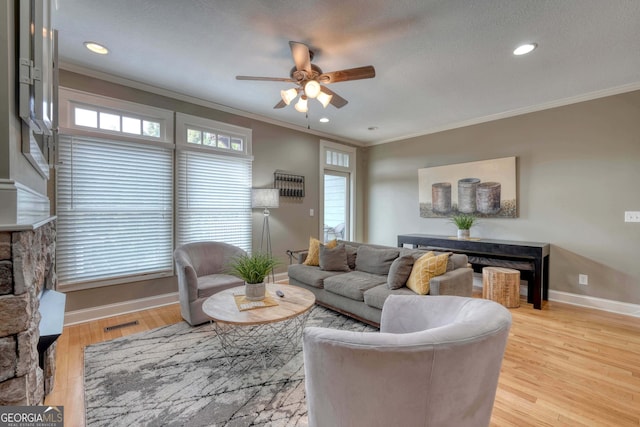 living room with a healthy amount of sunlight, a ceiling fan, and ornamental molding