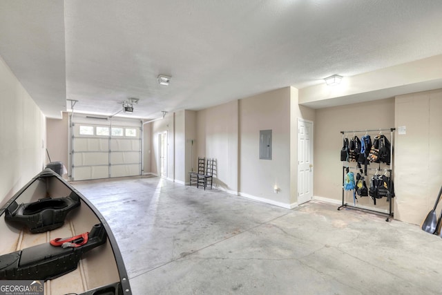 garage featuring electric panel and baseboards