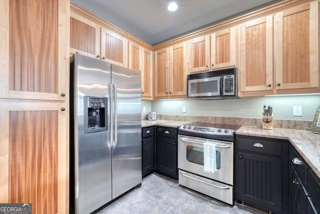 kitchen featuring light tile patterned floors, light stone countertops, light brown cabinets, and appliances with stainless steel finishes