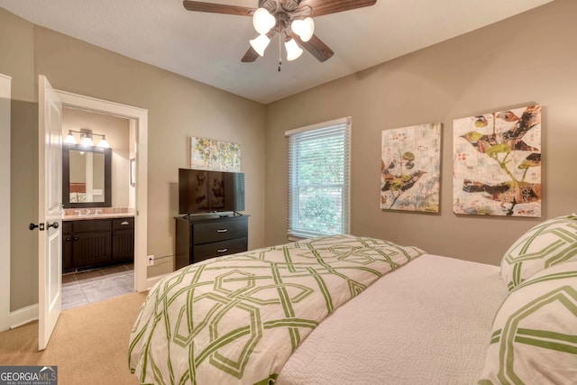 bedroom featuring connected bathroom, baseboards, ceiling fan, light carpet, and light tile patterned floors