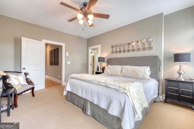 carpeted bedroom with visible vents, a ceiling fan, and baseboards