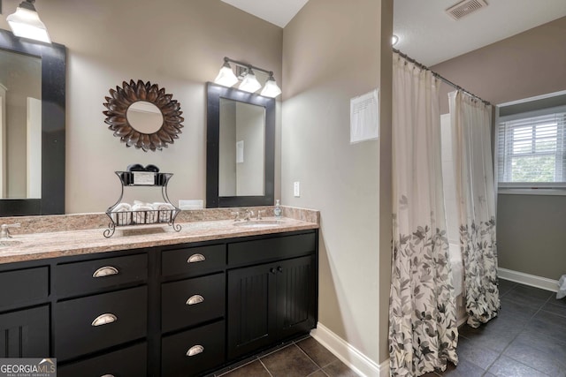 full bath with visible vents, baseboards, double vanity, tile patterned floors, and a sink