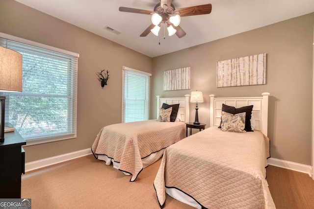 bedroom with a ceiling fan, baseboards, and visible vents