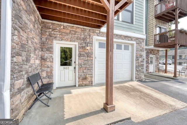 property entrance with stone siding and a balcony