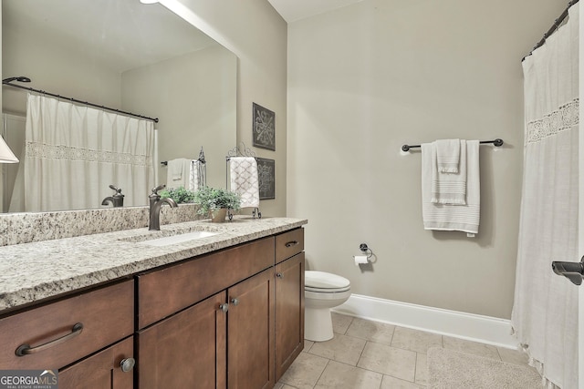 bathroom with vanity, toilet, baseboards, and tile patterned flooring