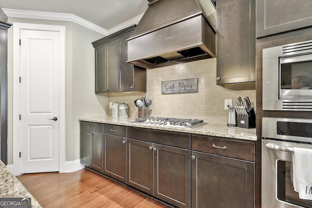 kitchen with custom exhaust hood, crown molding, dark brown cabinetry, and stainless steel appliances