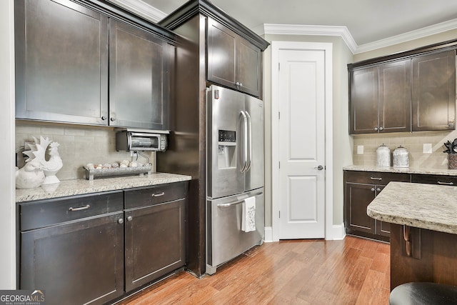 kitchen featuring tasteful backsplash, stainless steel fridge, dark brown cabinetry, crown molding, and light wood finished floors