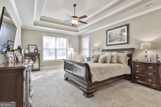 bedroom featuring visible vents, light colored carpet, crown molding, and a raised ceiling