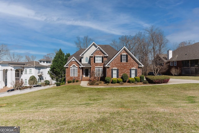 view of front of house featuring brick siding and a front yard
