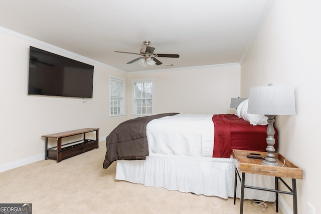 carpeted bedroom with ceiling fan, crown molding, and baseboards