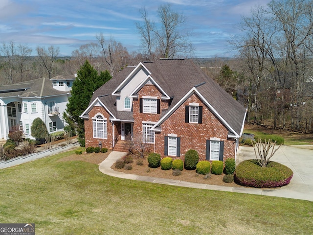 traditional home with brick siding, roof with shingles, concrete driveway, and a front lawn
