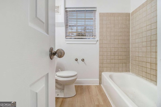 full bathroom featuring toilet, wood finished floors, and baseboards