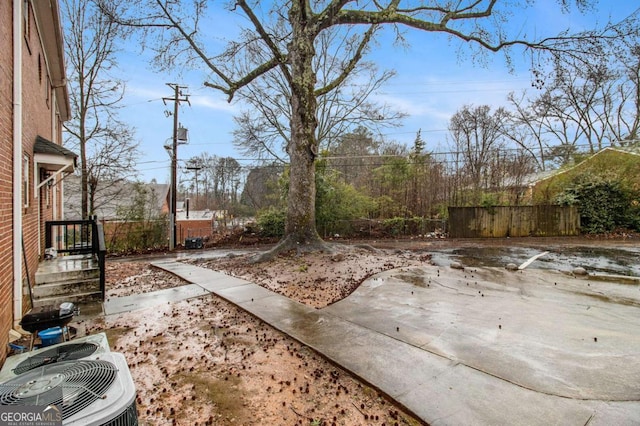 view of yard with cooling unit, a patio, and fence