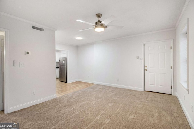 unfurnished living room featuring visible vents, light carpet, ornamental molding, a ceiling fan, and baseboards